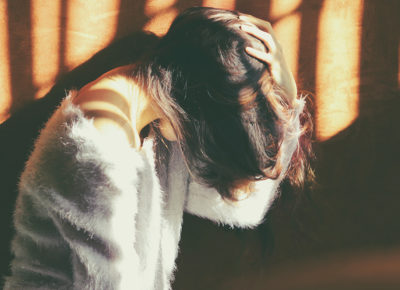 A woman with the fall doldrums puts her hand on her head.