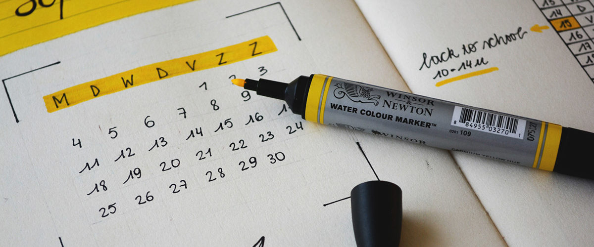 A highlighter on top of a calendar.