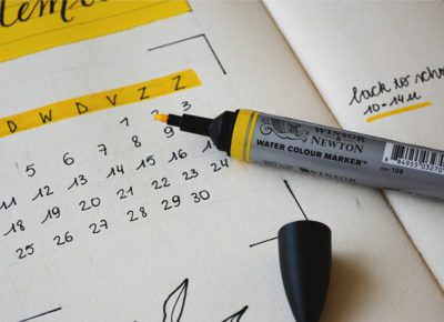 A highlighter on top of a calendar.