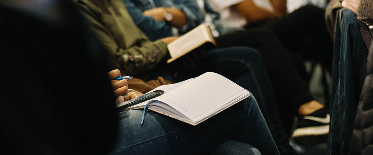 A group of volunteers taking notes in journals.