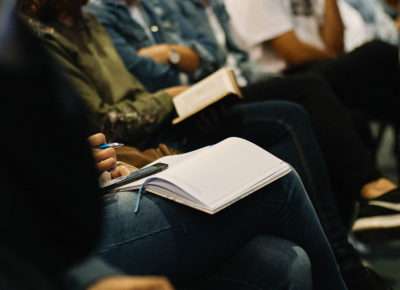 A group of volunteers taking notes in journals.